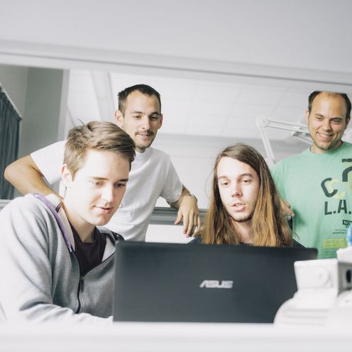 F&uuml;nf Studenten arbeiten an einem Laptop im Labor. 