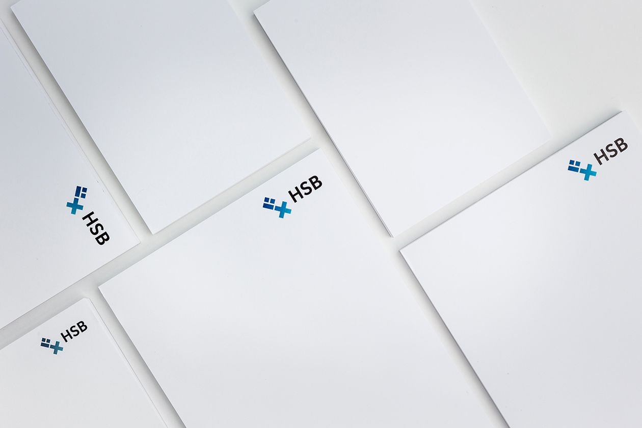 Nebeneinander liegen mehrere weiße Papierblöcke, die das HSB-Logo in der Kopfzeile tragen.