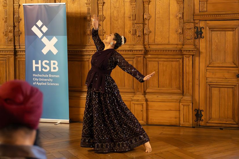 Frau tanzt im langen schwarz-glitzernden Kleid barfuß