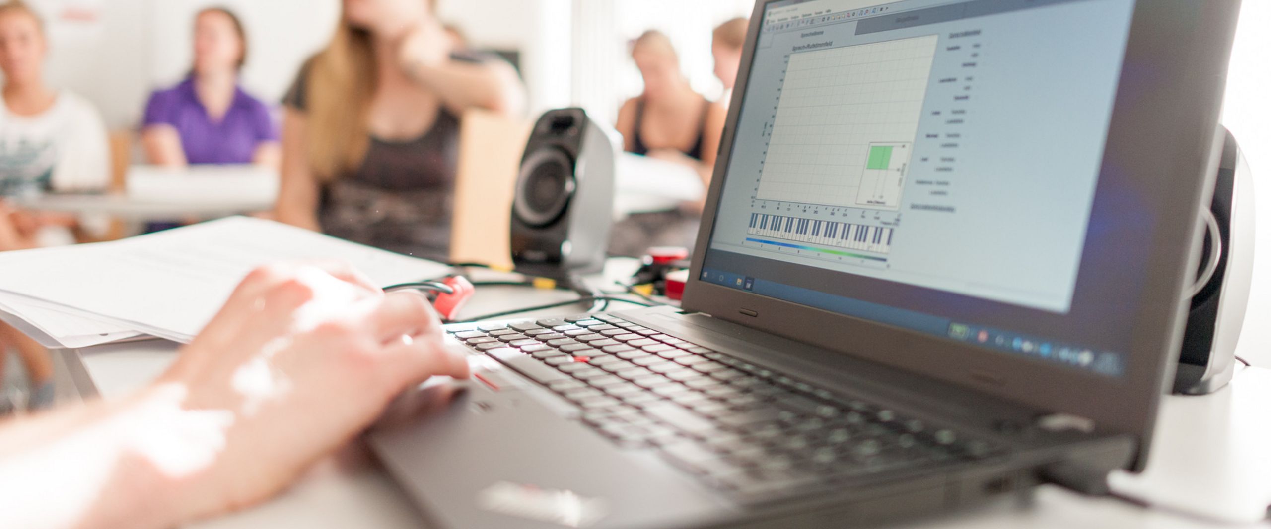 Laptop Laptop und Studierende unscharf im Hintergrund