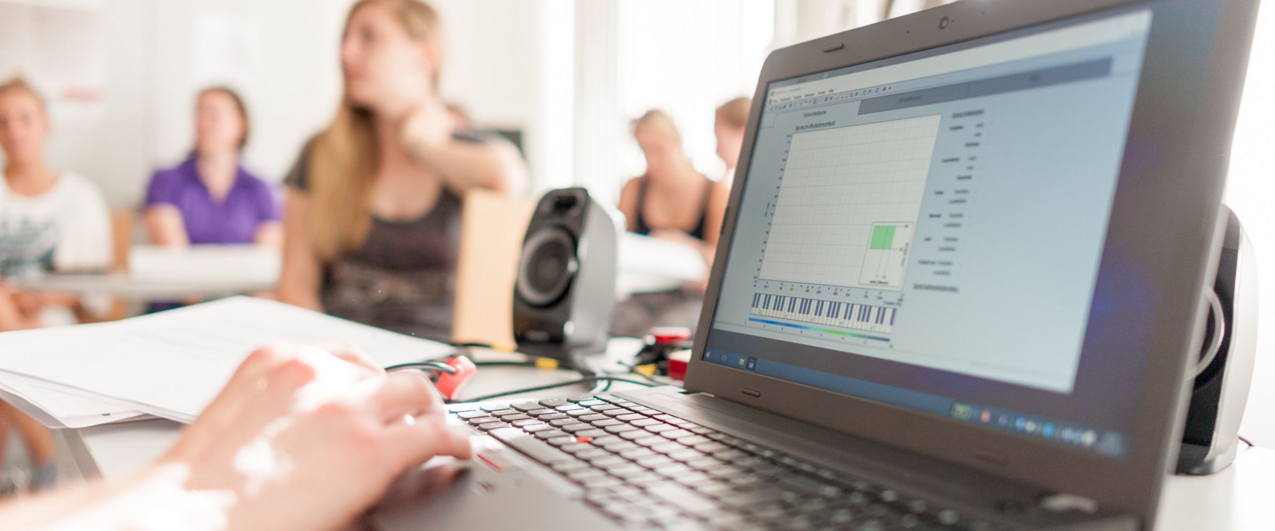 Laptop Laptop und Studierende unscharf im Hintergrund