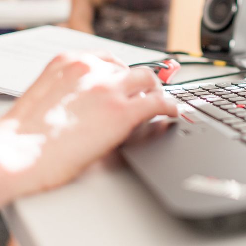 Laptop und Studierende unscharf im Hintergrund