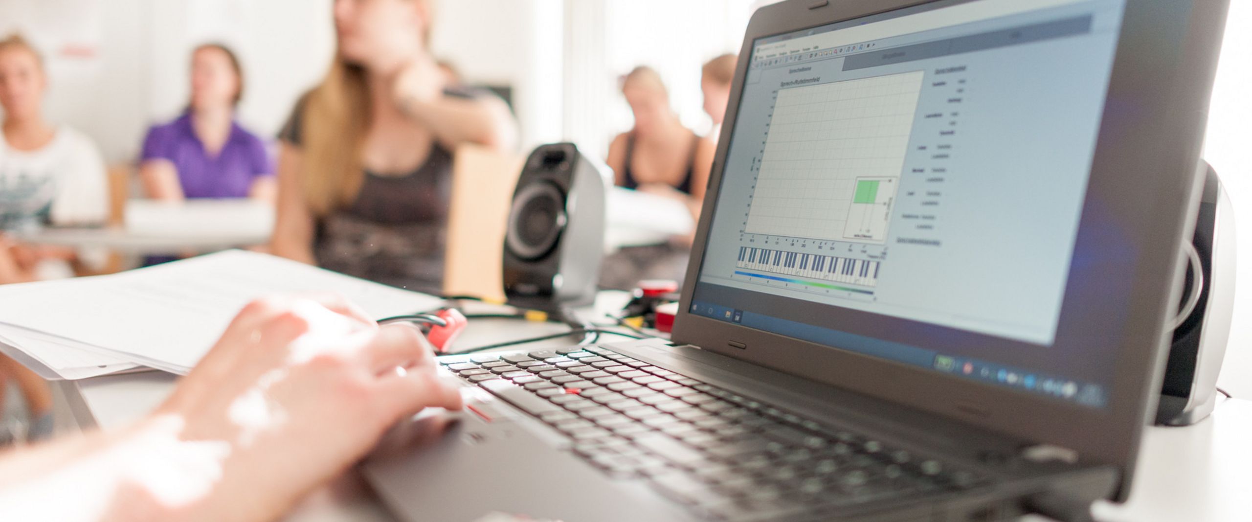 Laptop Laptop und Studierende unscharf im Hintergrund