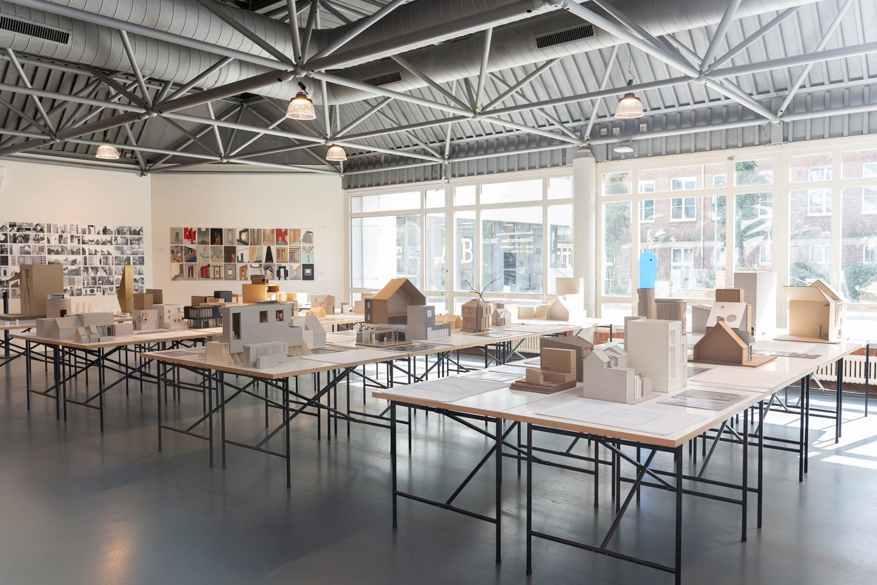 Tische mit Architekturmodellen und -zeichnungen