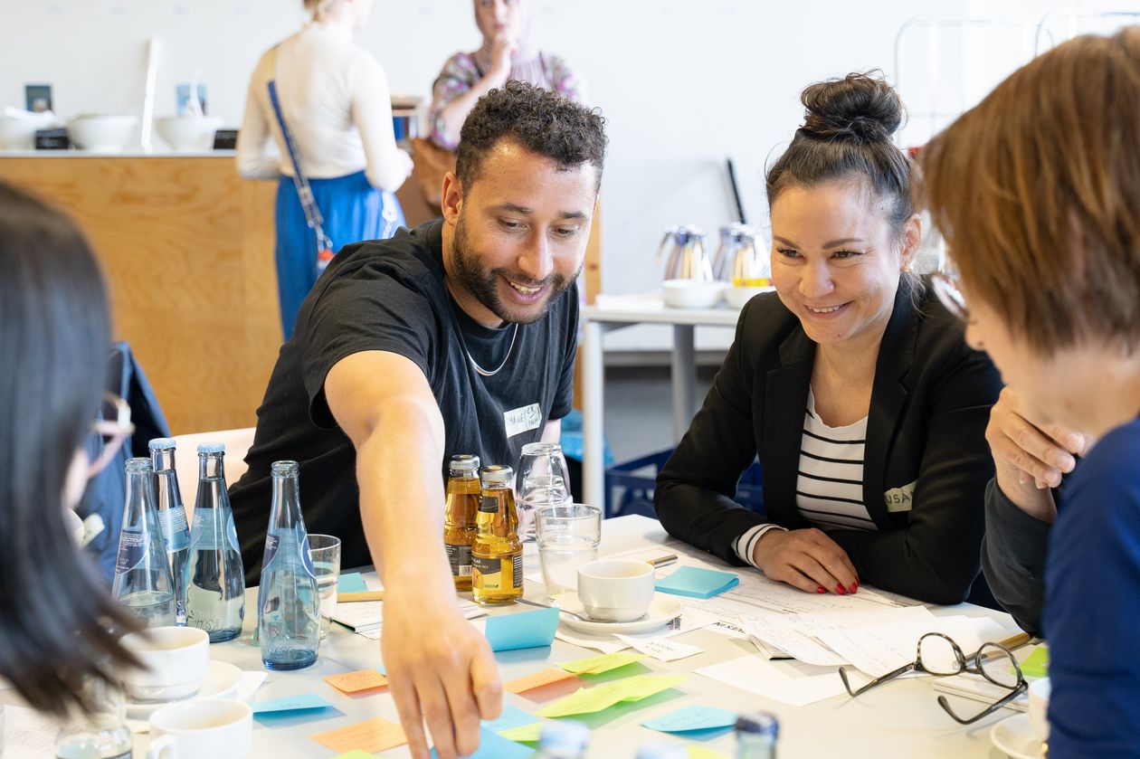 Mann und zwei frauen sitzen am Tisch und interagieren miteinander