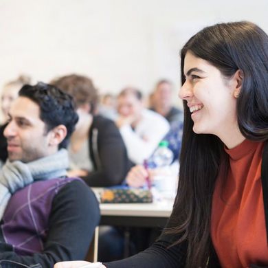 Students smiling and engaged during a university lecture or seminar.