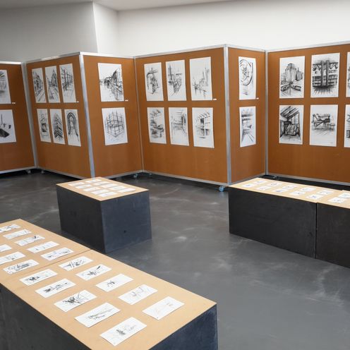 Raum mit Kohelzeichnungen an Stellw&auml;nden und B&auml;nken