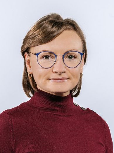 Auf dem Foto ist Jessica Langolf zusehen. Sie hat kinnlanges blindes Haar und trägt einen roten Pullover und eine blaue Brille. 