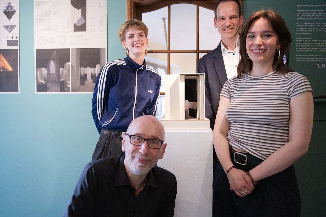 gruppenbild mit zwie M&auml;nnern und zwei jungen Fauen. In der Mitte steht ein kleines Architekturmodell