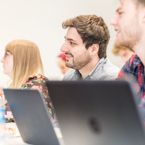 Studierende vor Laptops h&ouml;ren eine Vorlesung. 