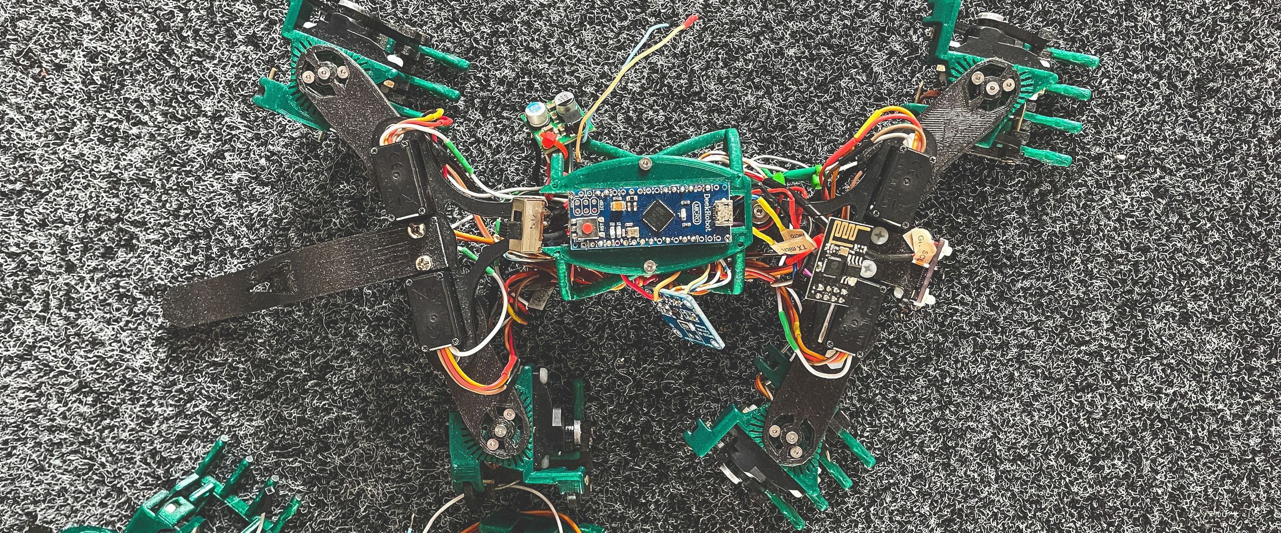 Das Bild zeigt einen Laufroboter an einer vertikalen Wand.