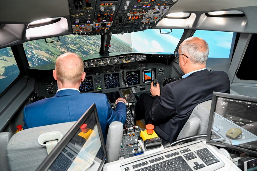 Zwei M&auml;nner sitzen in einem Flugzeugcockpit.