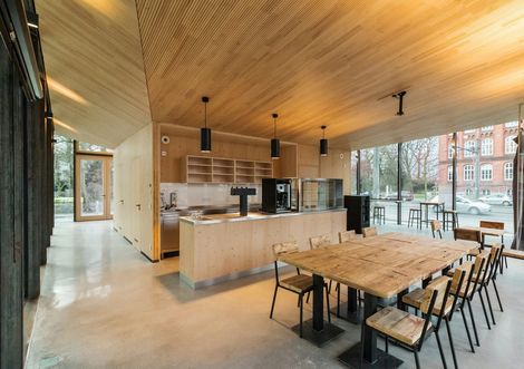 Innenansicht des Fahradrepaircafés mit Blick auf die Theke und Gastraum mit Tischen und Stühlen