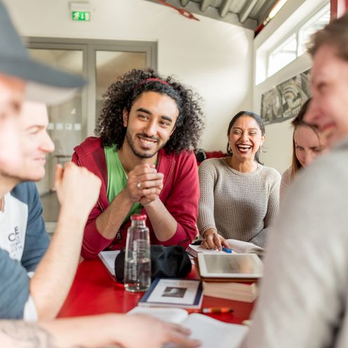 Eine Gruppe Studierender sitzt an einem Tisch und lernt gemeinsam.