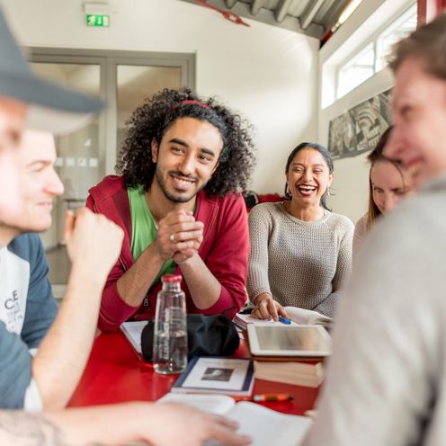 Eine Gruppe Studierender sitzt an einem Tisch und lernt gemeinsam.
