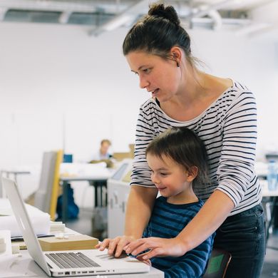 Mutter sitzt mit Kind in der Vorlesung
