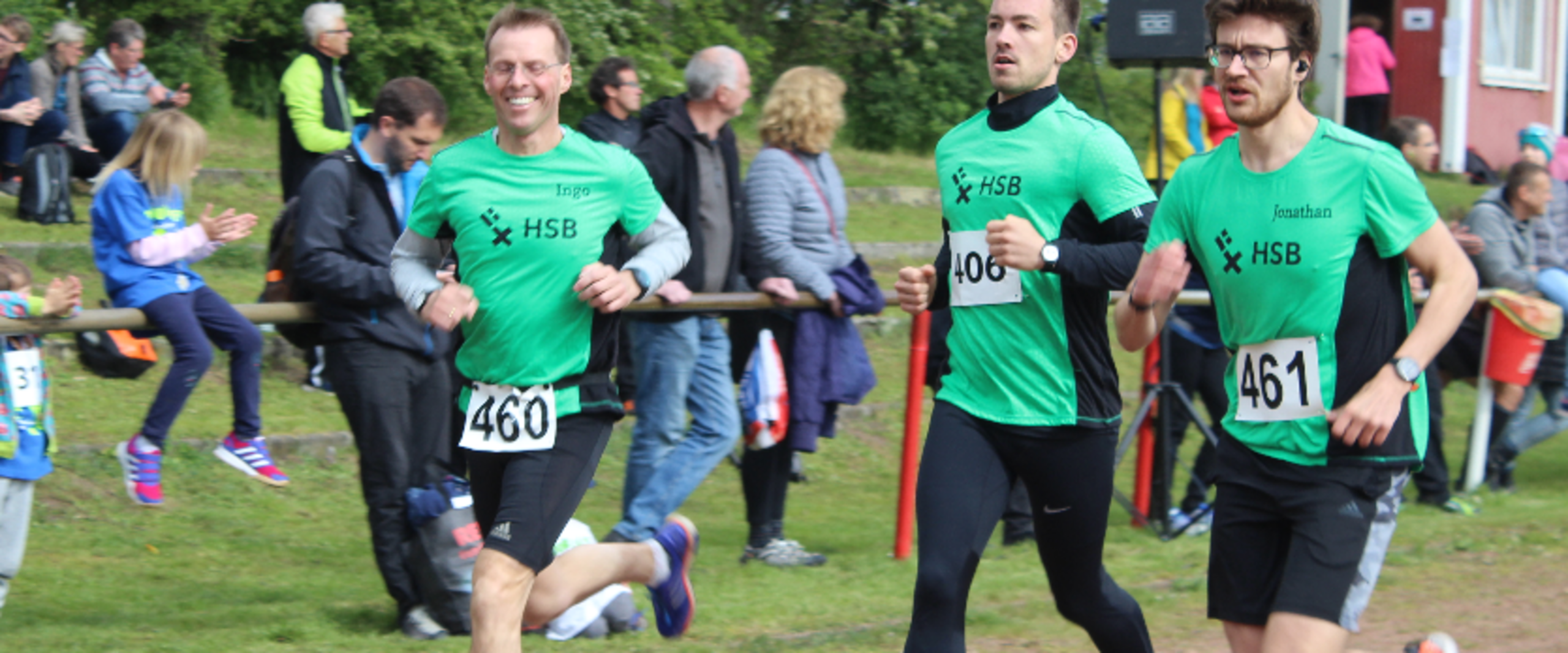 Drei L&auml;ufer rennen die Strecke entlang.