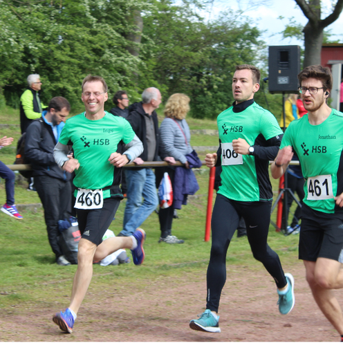 Drei L&auml;ufer rennen die Strecke entlang.