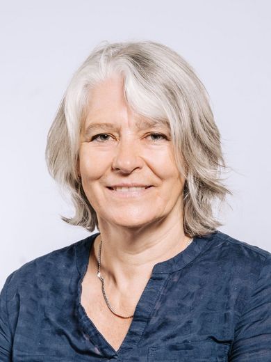 Auf dem Foto ist Hanna Bickhardt zu sehen. Sie hat schulterlanges graues Haar und trägt eine blaue Bluse. 