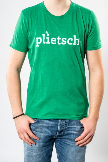 Das Model trägt ein grünes T-Shirt für Herren mit der Aufschrift “plietsch“.