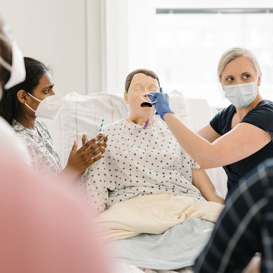 Studierende üben mit Sondenkost, Stoma, Magensonde an einer Puppe