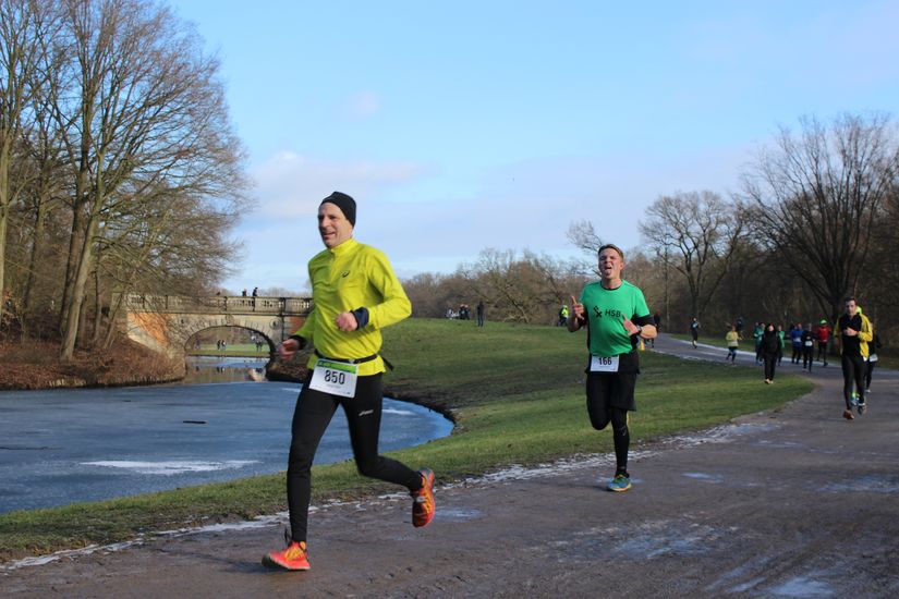 Zwei L&auml;ufer laufen an einem Fluss entlang.