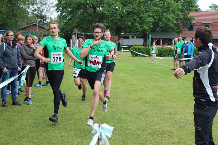 L&auml;ufer sind kurz vor dem Ziel. An der Seite stehen Zuschauer.