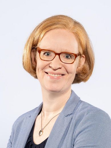 Auf dem Foto ist Dorothea Br&uuml;ggemann zusehen. Sie hat kinnlanges, rotes Haar. Sie tr&auml;gt eine Brille und einen hellblauen Balzer &uuml;ber einem schwarzen T-Shirt. 