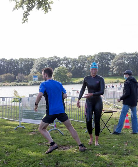 Eine Schwimmerin &uuml;bergibt an einen L&auml;ufer beim Werdersee Swim & Run 2020.