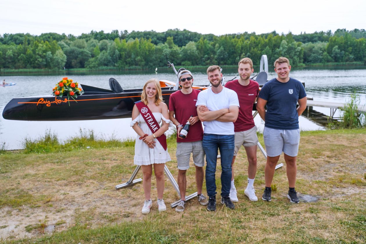 % junge Menschen, 4 M&auml;nner, eine Frau, stehen vor dem Tretboot Reignbow. Das Foto zeigt: Anna Augenstein (Vorsitzende Fachschaft &bdquo;Straak zu Bremen&ldquo;, Studierende &lsquo;Schiffbau und Meerestechnik&rsquo; B. Eng.), Eike Harms (Projektleiter des Tretbootes &bdquo;Reignbow&ldquo;, Studierender &lsquo;Schiffbau und Meerestechnik&rsquo; B.Eng.), Julius Zielke (Absolvent &lsquo;Schiffbau und Meerestechnik&rsquo; B. Eng. und Teilprojektleiter &bdquo;Reignbow&ldquo;), Erik Faber (Absolvent Schiffbau und Meerestechnik&rsquo; B. Eng. Projektbeteiligter), Max Koltmann (Absolvent Schiffbau und Meerestechnik&rsquo; B. Eng. Projektbeteiligter) 