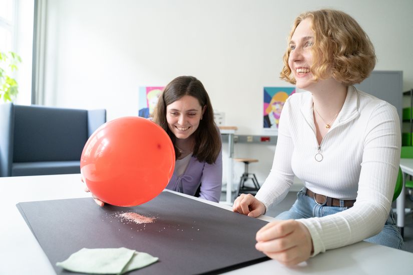 Zwei HSB Studierende f&uuml;hren ein Experiment mit einem Luftballon und Styropor durch. 