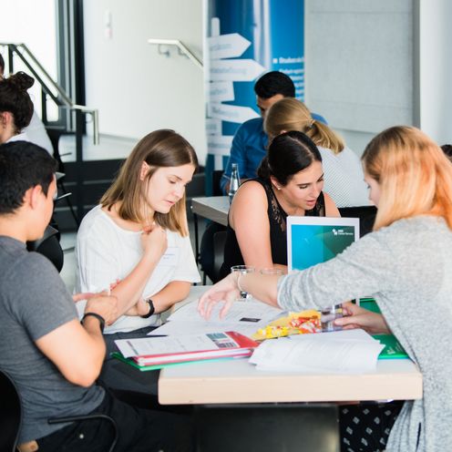 Studierende bei einer Gruppenarbeit an einem Tisch 