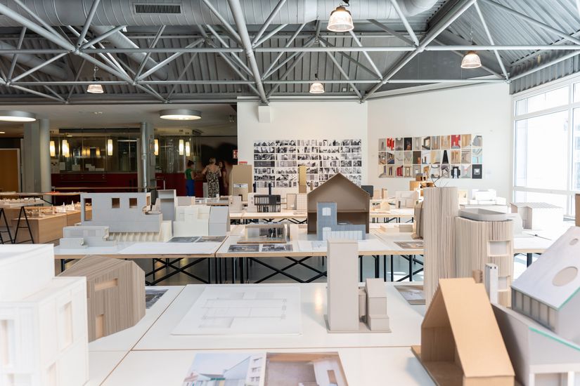 Tische und Wände mit Architekturmodellen und -zeichnungen