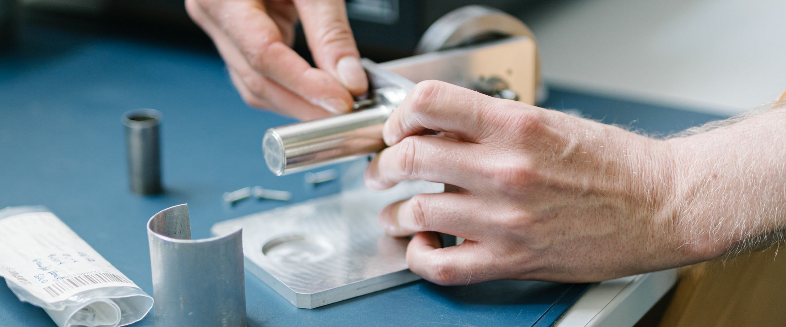 Stirlingmotor Eine Person schraubt an einem Stirlingmotor in Miniaturgröße.