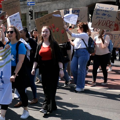 Menschen halten große Transparente und laufen zusammen in einem Deomonstrationszug