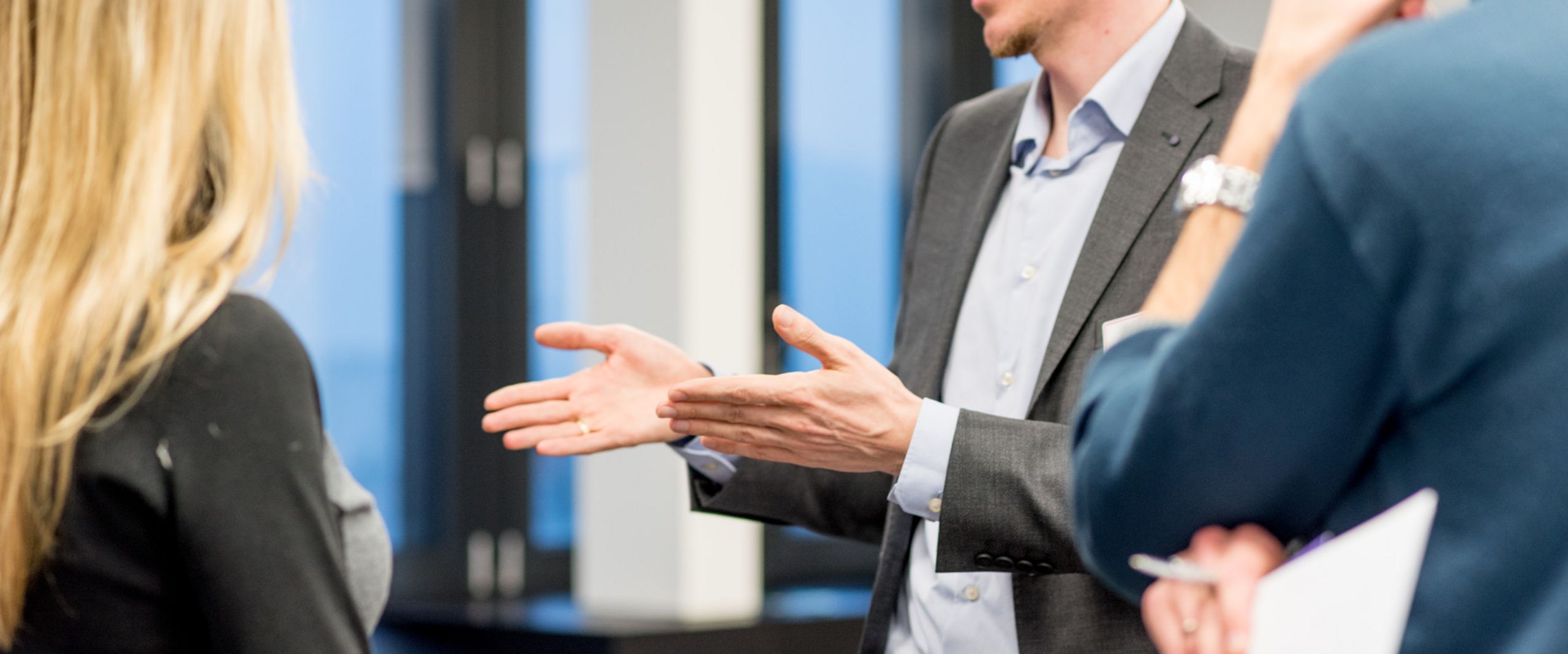 Karriere Ein Vertreter eines Unternehmens unterhält sich mit einer kleinen Gruppe Studierender.