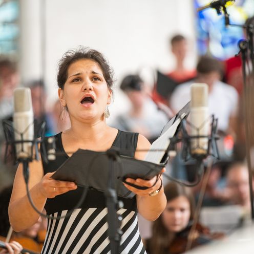 Eine Chors&auml;ngerin singt ihr Solo mit Notenbuch in der Hand.