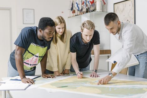 Nautikstudierende arbeiten mit Seekarten.