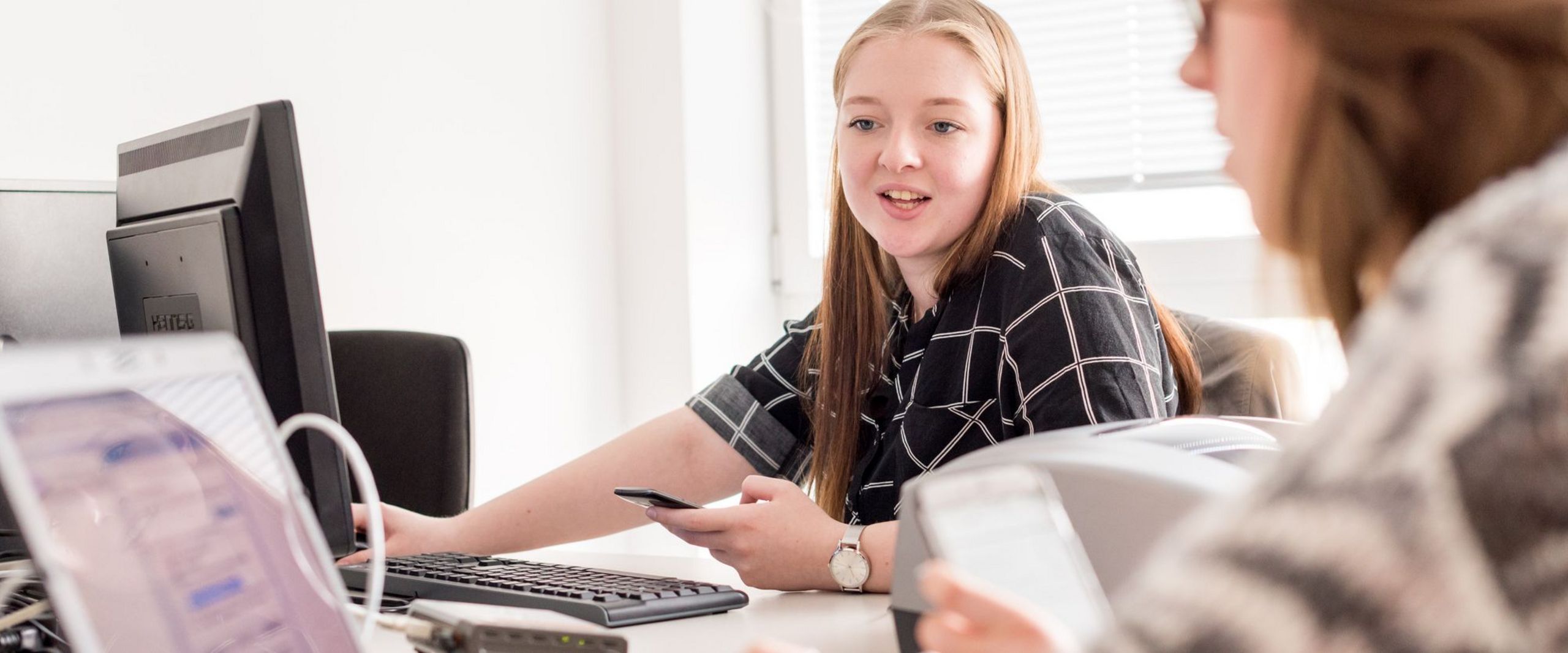 Zwei Studentinnen programmieren am Computer. 