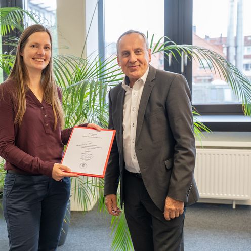 Ernennung Prof. Dr. LIsa Gutzeit Bionik Frau und Man lachen in die Kamera. Sie hält eine Urkunde