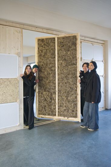 Junge Menschen stehen neben einer mobilen Wand