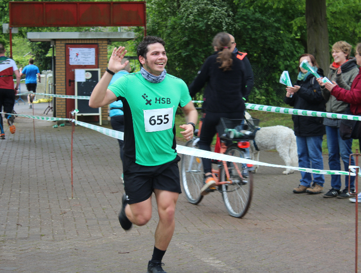 Ein winkender L&auml;ufer der l&auml;chelt.