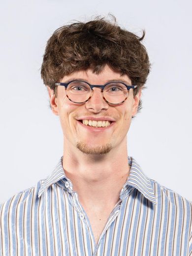 Auf dem Foto ist Yannick Gerling zusehen. Er hat braune lockige, kurze Haare. Er tr&auml;gt eine Brille und ein blau-wei&szlig; gestreiftes Hemd. 