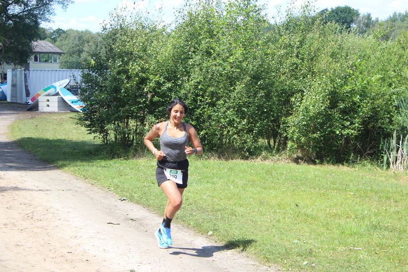 Eine L&auml;uferin auf einem ungepflasterten Weg.