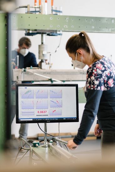 Studentin prüft Messwerte auf einem Monitor im Traglast-Labor