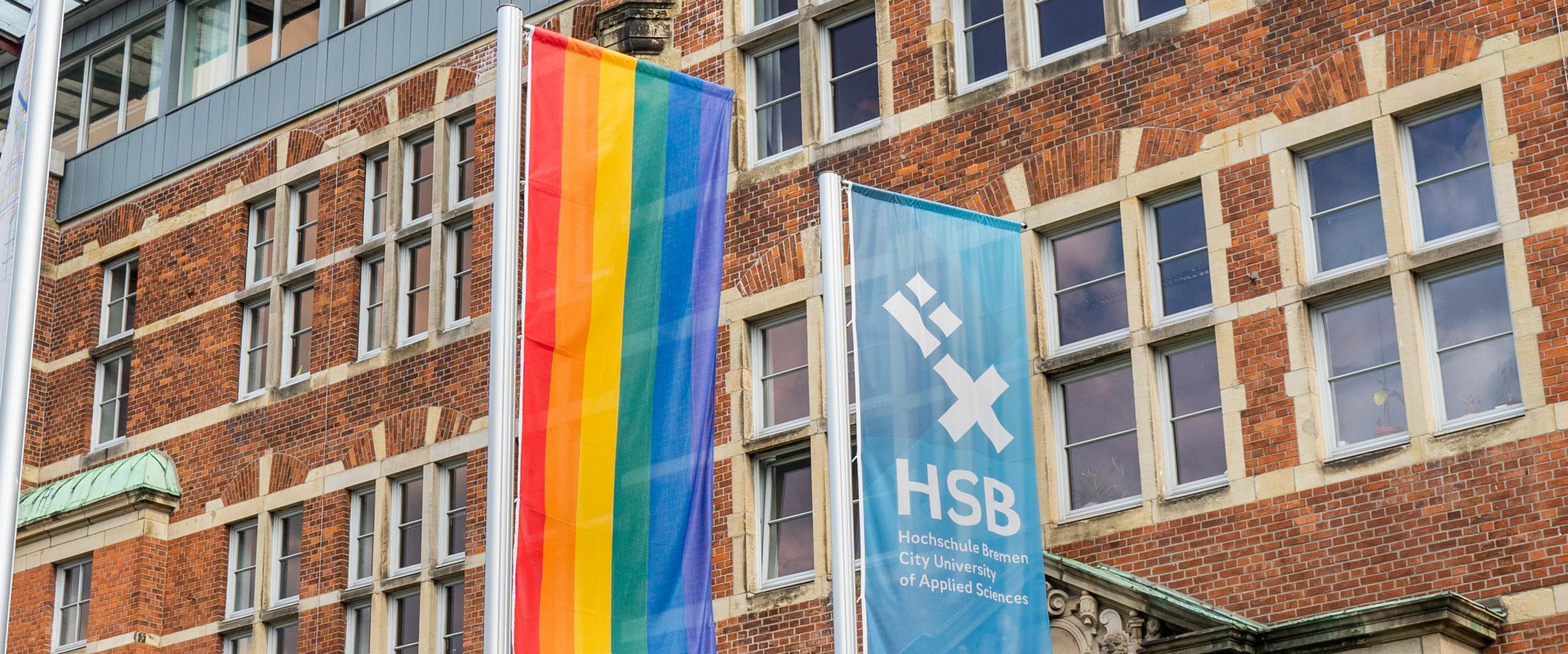Eine Regenbogenflagge neben der HSB-Flagge.