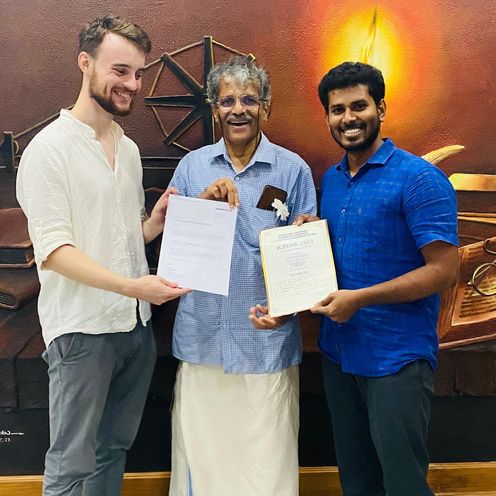 gruppenbild mit drei M&auml;nnern, die zwei Urkunden halten.