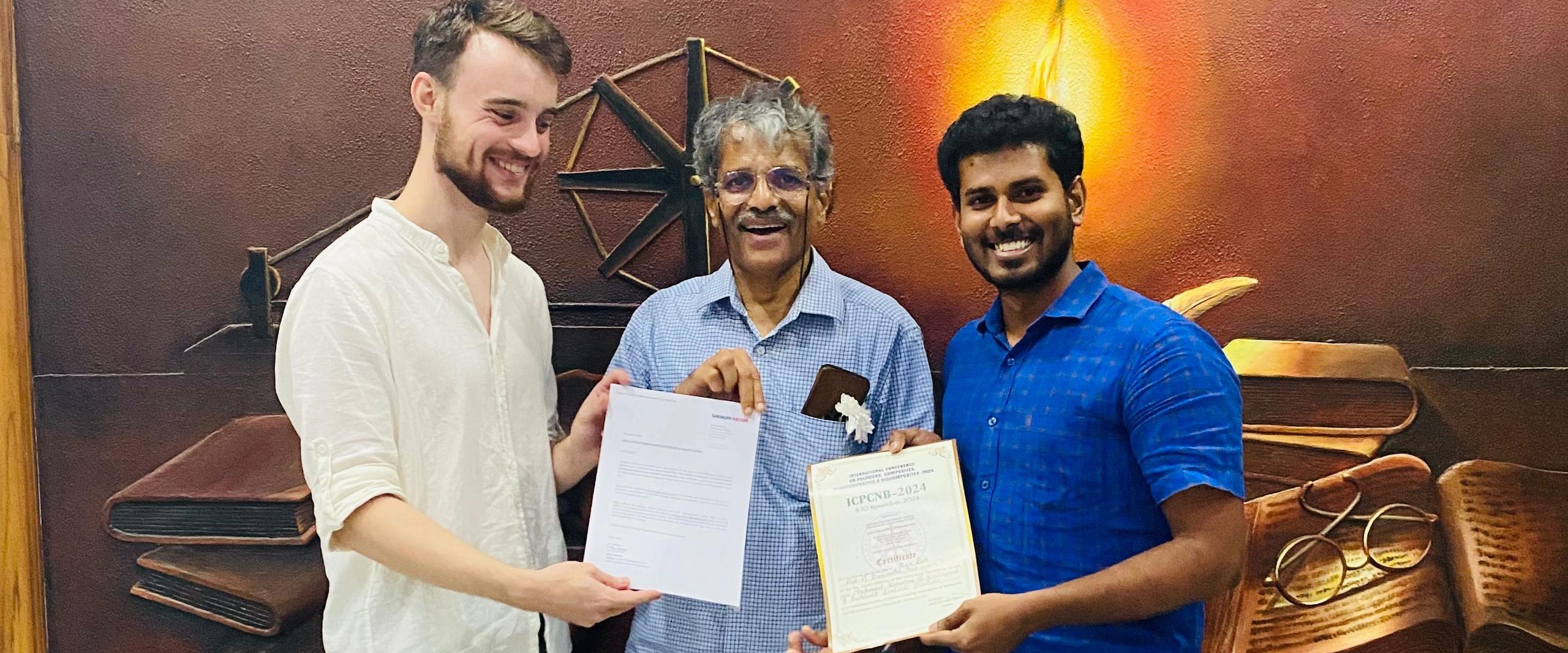 ICPCNB 2024 Auszeichnung Bioniker gruppenbild mit drei Männern, die zwei Urkunden halten.