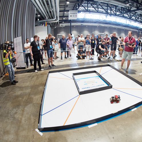 Parcours mit kleinen Robotern und vielen Menschen