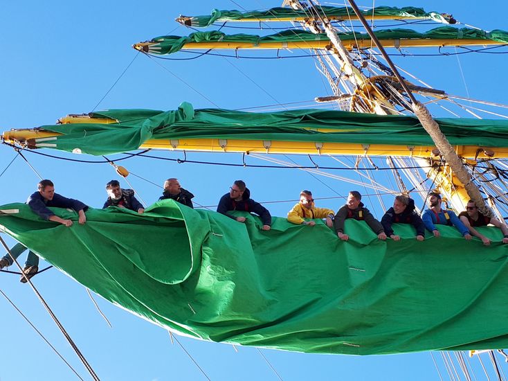 Studierende sitzen in der Takelage des Segelschiffs Alexander von Humboldt II. 